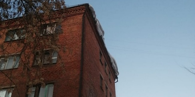 Управляющую компанию заставили очистить от снежных завалов крышу общежития на окраине Омска